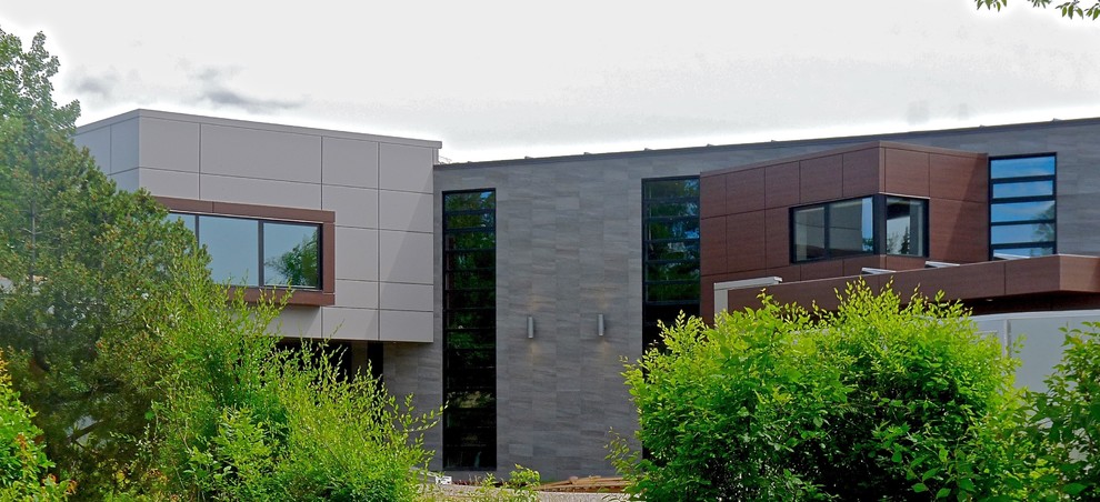 Aménagement d'une grande façade de maison grise contemporaine à deux étages et plus avec un revêtement mixte et un toit plat.