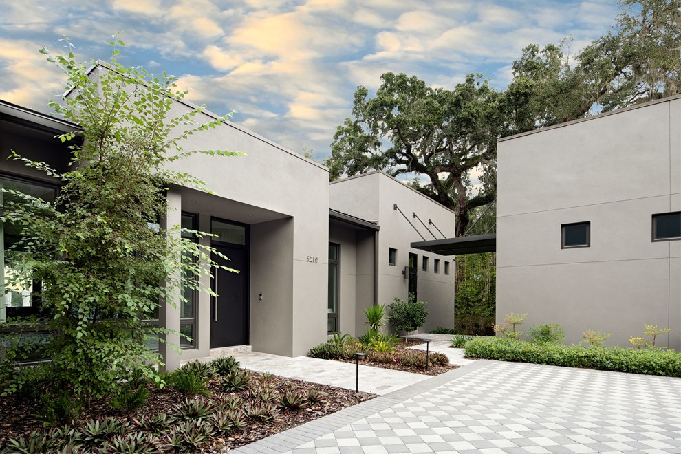 Пример оригинального дизайна: большой, одноэтажный, серый дом в стиле модернизм с облицовкой из бетона и плоской крышей