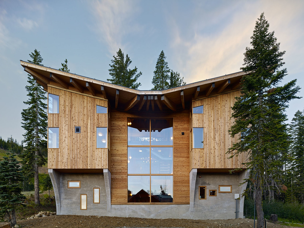 Exemple d'une très grande façade de maison marron montagne en bois à deux étages et plus avec un toit papillon.
