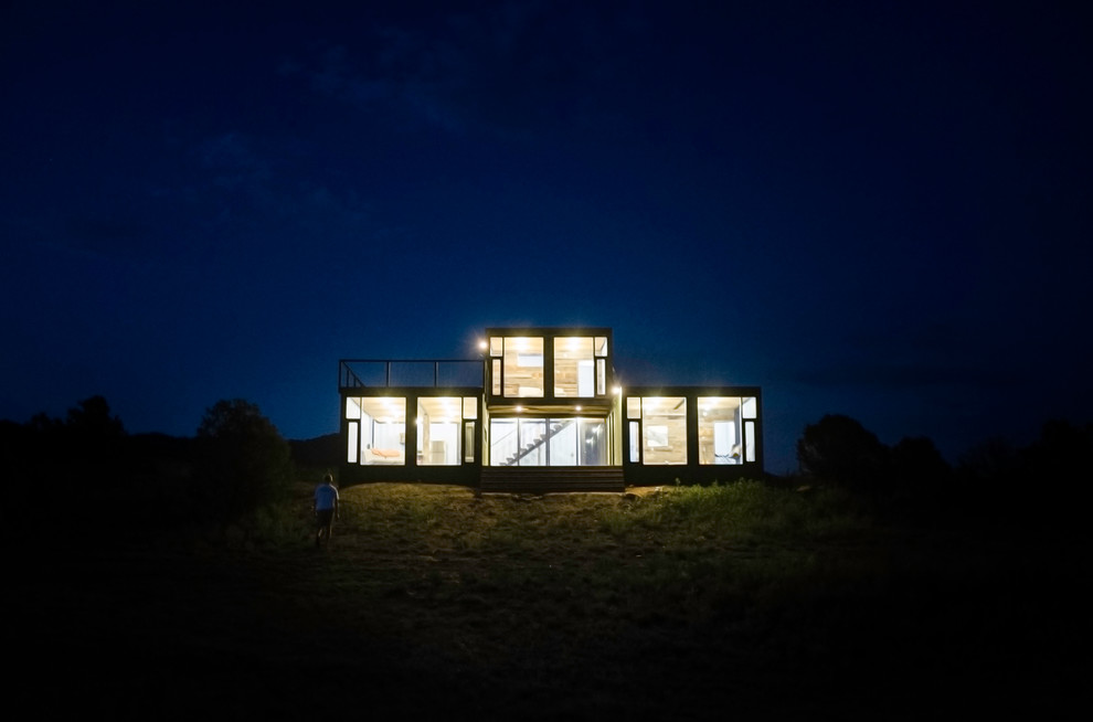 Cette image montre une petite façade de maison container métallique et verte urbaine à un étage avec un toit plat.