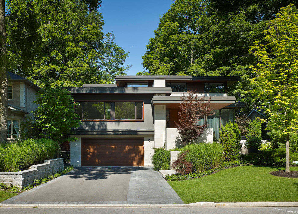 Пример оригинального дизайна: серый дом среднего размера в стиле модернизм с разными уровнями и комбинированной облицовкой