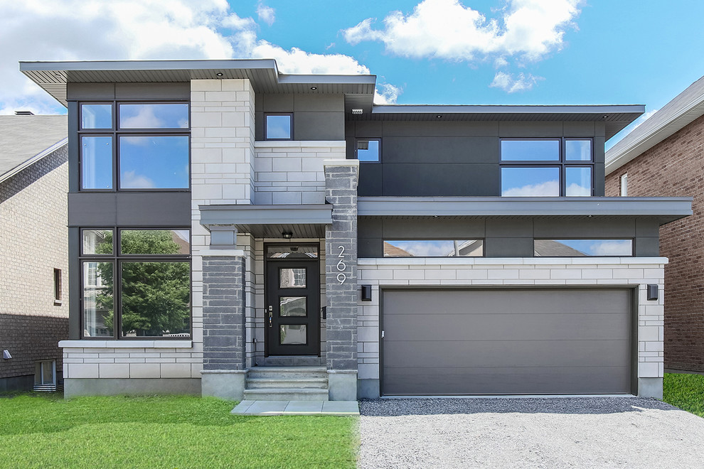 Inspiration pour une façade de maison grise design à un étage avec un revêtement mixte et un toit plat.