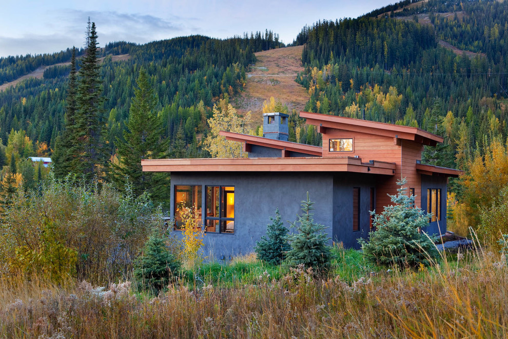 Example of a huge mountain style gray two-story stucco exterior home design in Other