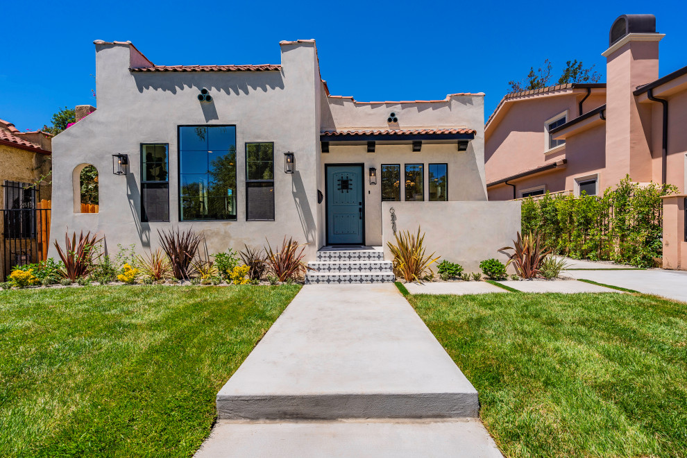 Mediterranes Einfamilienhaus mit beiger Fassadenfarbe und Ziegeldach in Los Angeles