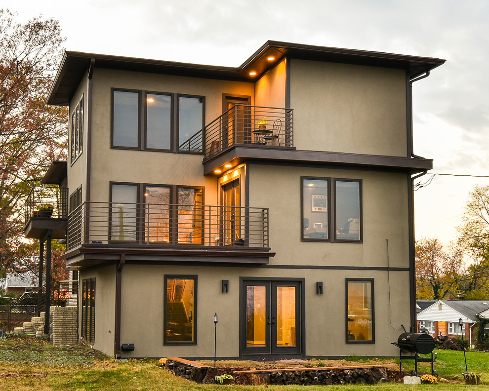 Imagen de fachada de casa beige moderna grande a niveles con revestimiento de estuco y tejado plano