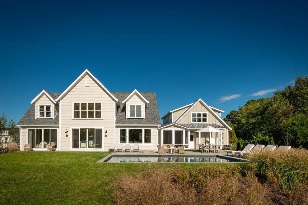 Ejemplo de fachada de casa beige campestre extra grande de dos plantas con revestimientos combinados, tejado a dos aguas y tejado de teja de madera