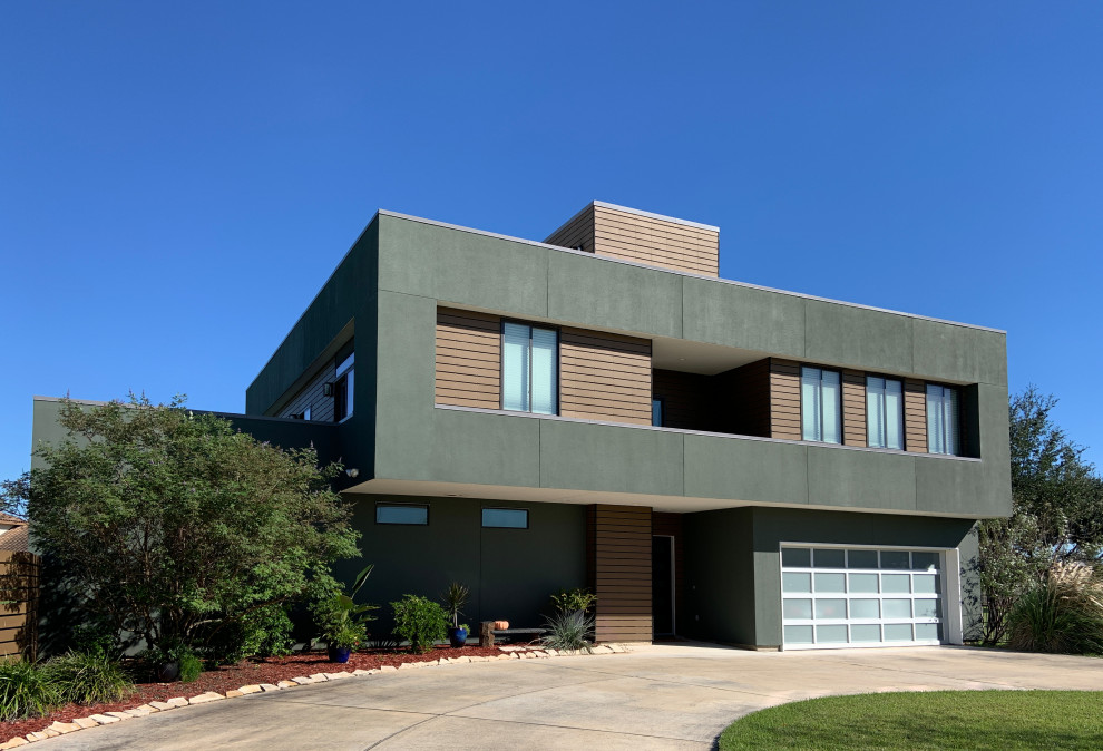 Photo of a medium sized and green modern two floor house exterior with mixed cladding and a flat roof.