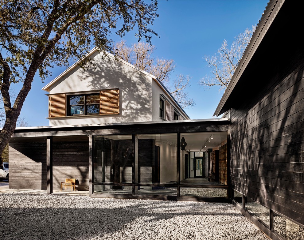 Example of a minimalist black two-story mixed siding house exterior design in Austin with a metal roof and a shed roof