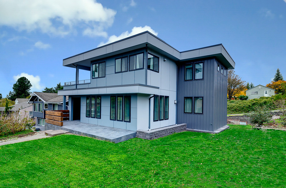 Ejemplo de fachada gris minimalista grande de tres plantas con revestimientos combinados y tejado plano
