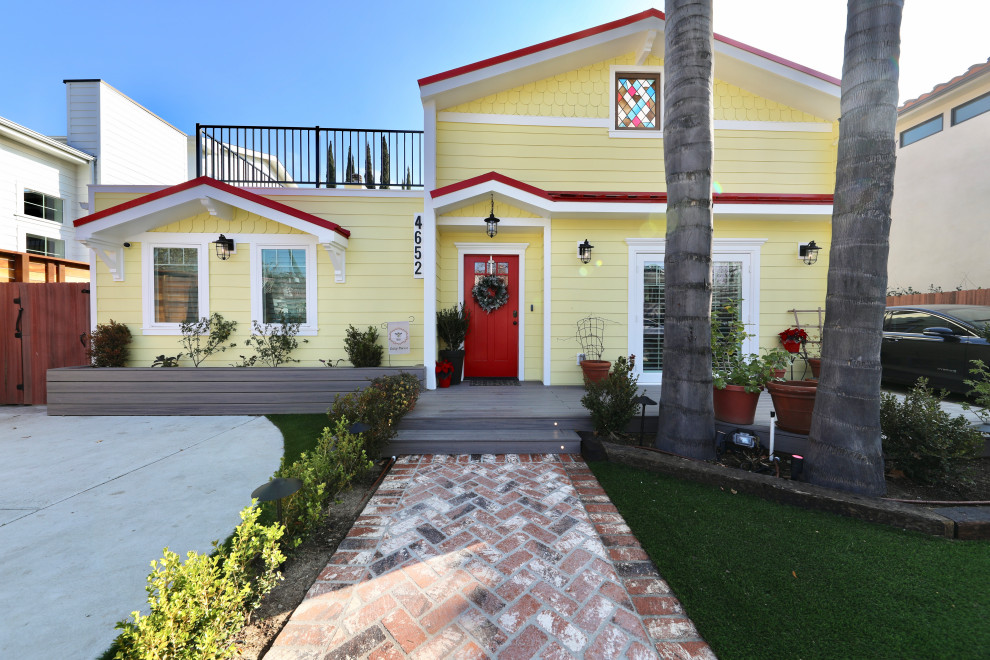 Ejemplo de fachada de casa amarilla moderna grande de dos plantas con revestimiento de madera y tejado de metal