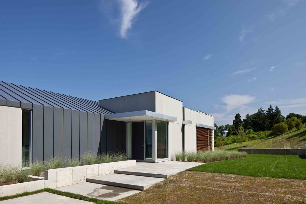 Ejemplo de fachada gris moderna de una planta con revestimiento de aglomerado de cemento