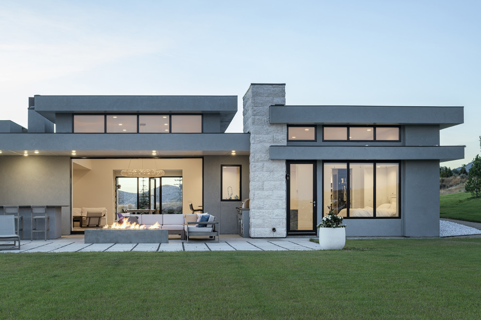 Großes, Einstöckiges Modernes Einfamilienhaus mit Putzfassade, grauer Fassadenfarbe, Flachdach und Blechdach in Sonstige