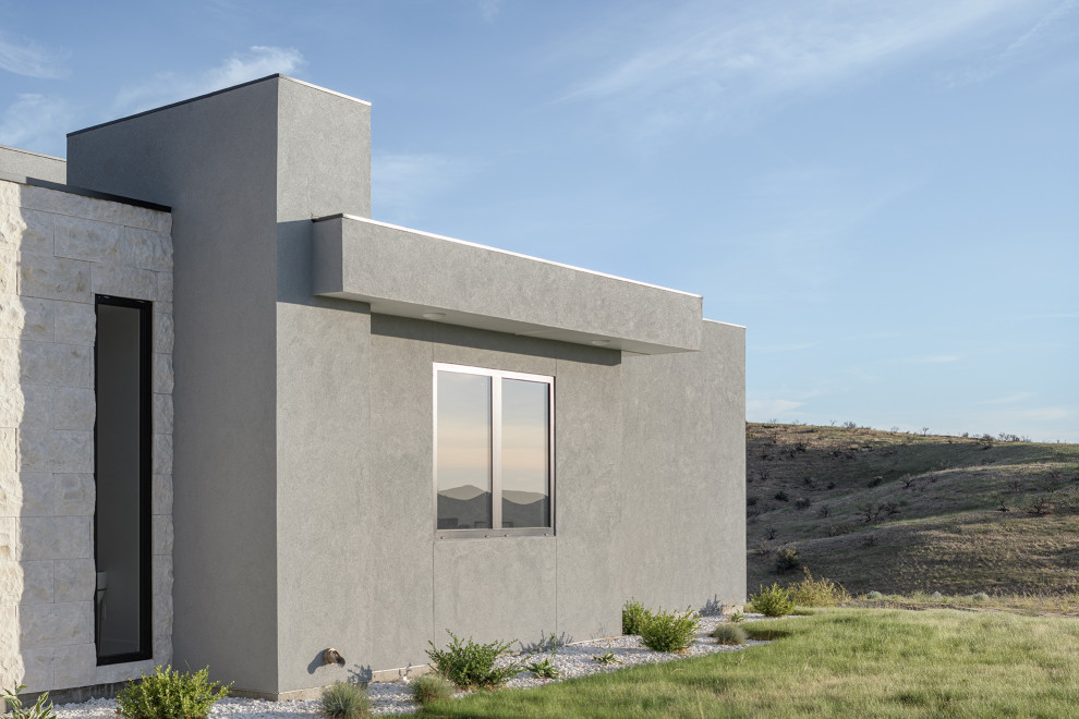 Idées déco pour une grande façade de maison grise moderne en stuc de plain-pied avec un toit plat et un toit en métal.