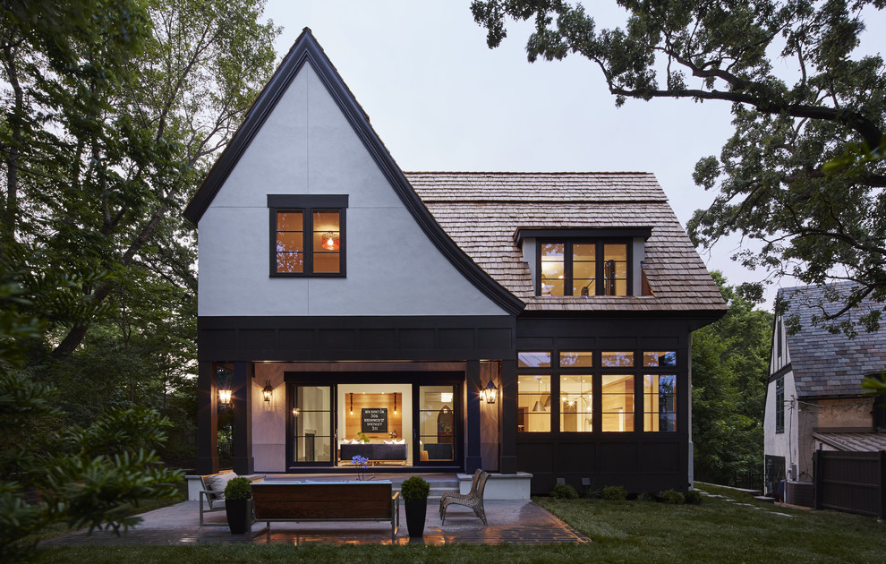 Cette photo montre une façade de maison blanche chic en stuc à un étage avec un toit à deux pans.