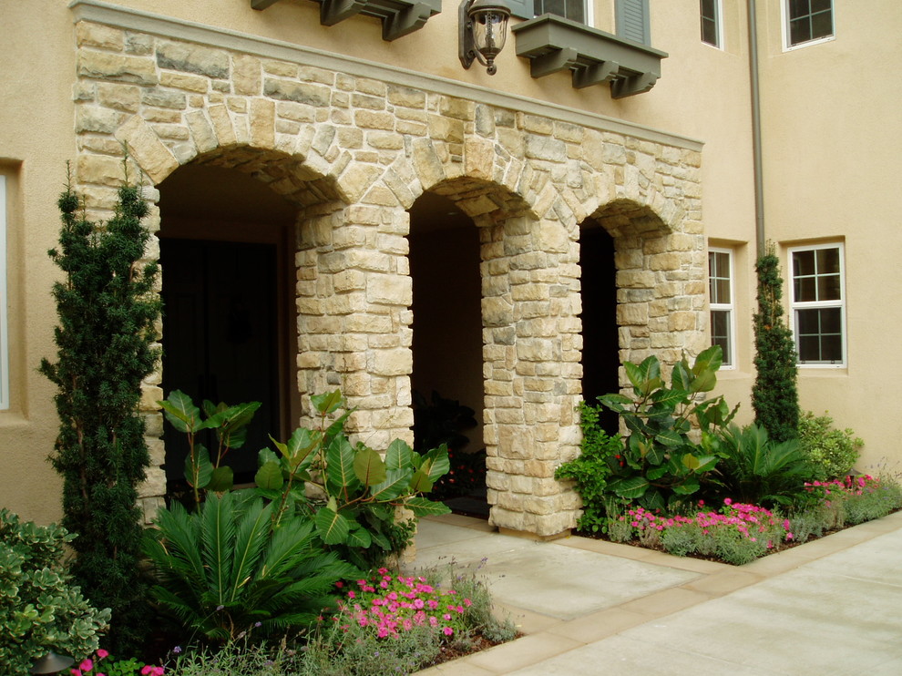 На фото: двухэтажный, бежевый, большой частный загородный дом в средиземноморском стиле с облицовкой из камня