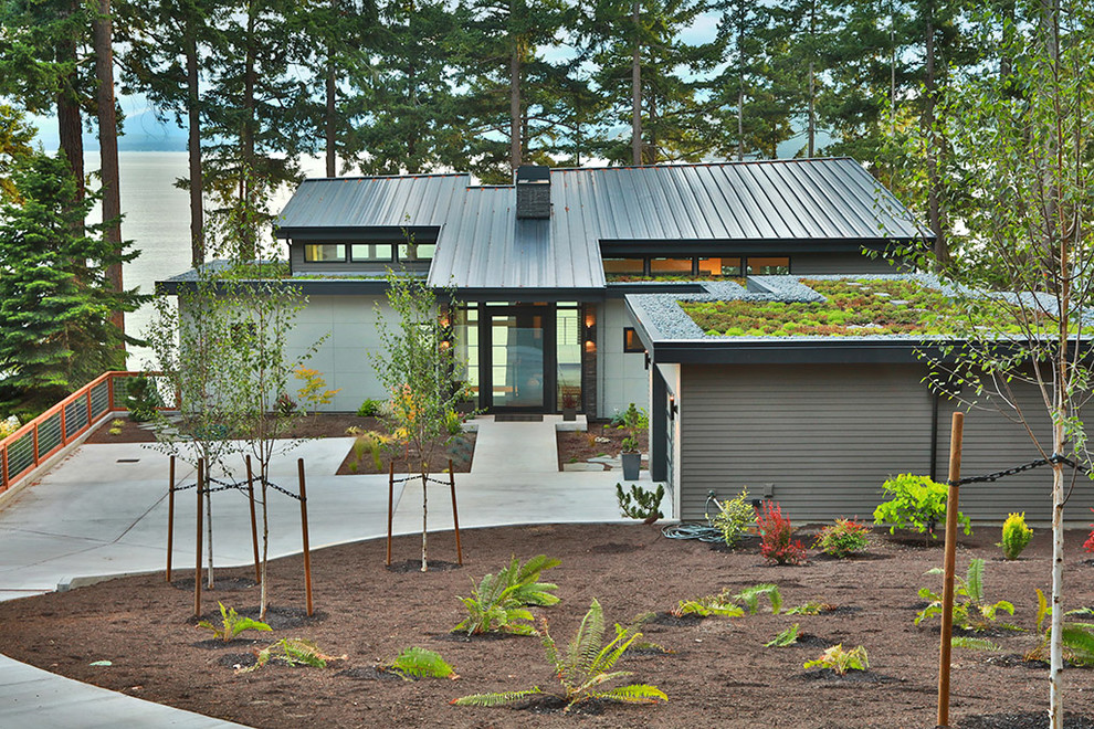 Aménagement d'une grande façade de maison multicolore moderne à un étage avec un revêtement mixte, un toit en appentis et un toit en métal.