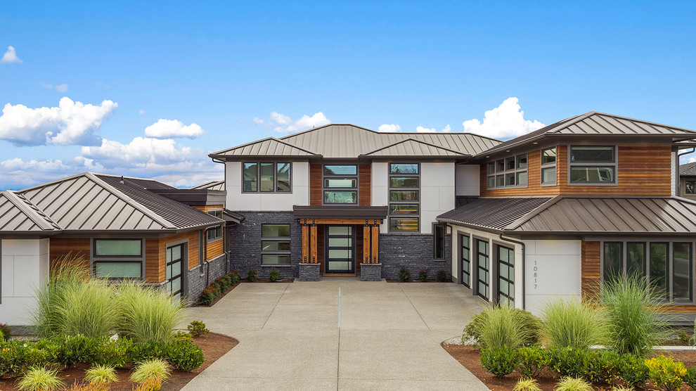Ejemplo de fachada de casa gris contemporánea grande de dos plantas con revestimientos combinados, tejado a cuatro aguas y tejado de metal