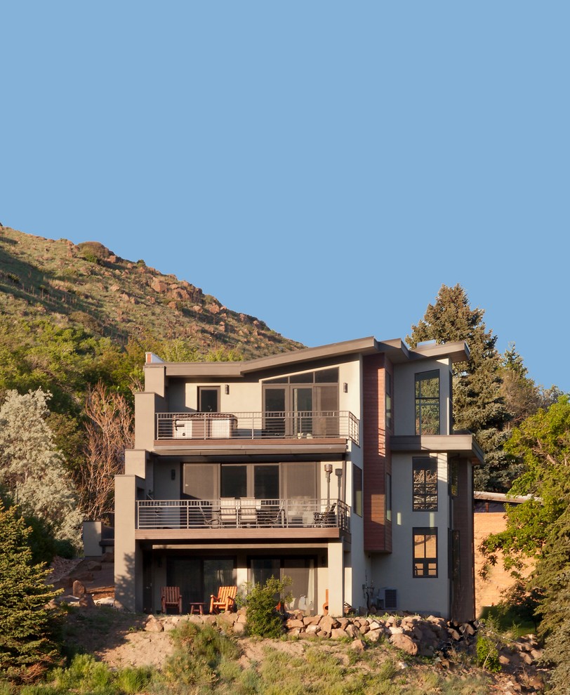 Imagen de fachada de casa beige contemporánea grande de tres plantas con tejado plano y revestimientos combinados
