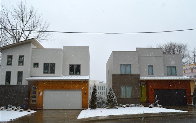 Cette photo montre une grande façade de maison tendance en stuc à un étage.