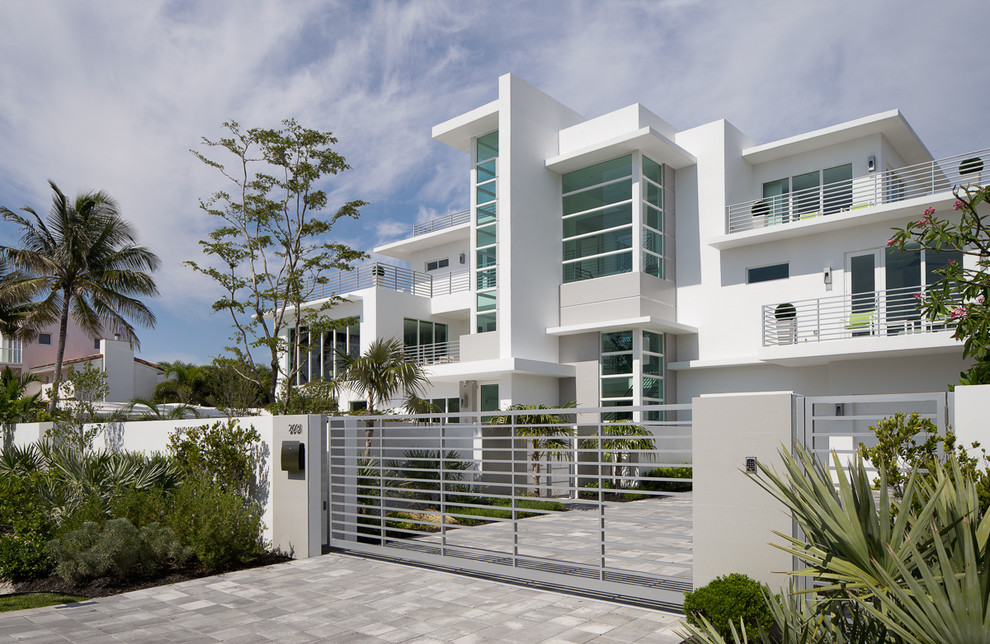 Photo of an expansive and white modern concrete house exterior in Miami with three floors.