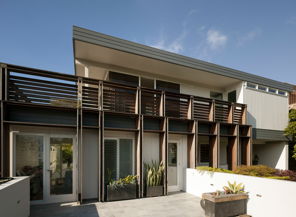 Источник вдохновения для домашнего уюта: двухэтажный, кирпичный, серый частный загородный дом среднего размера в стиле ретро с плоской крышей и металлической крышей