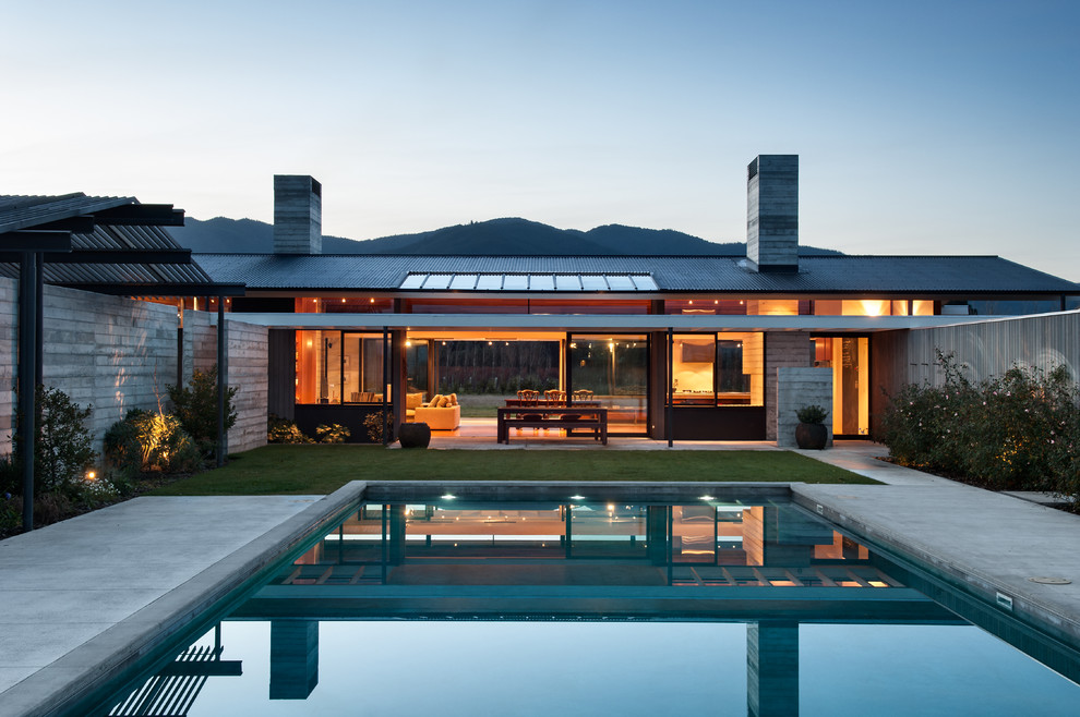 Exemple d'une grande façade de maison tendance en verre de plain-pied avec un toit à deux pans.