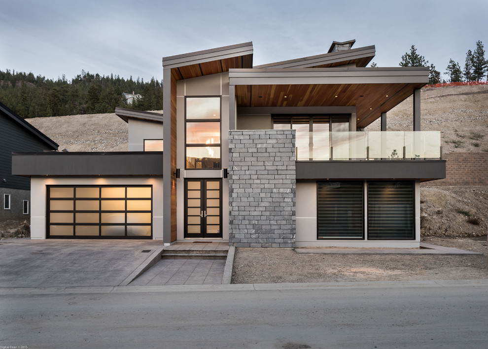 This is an example of a large and gey contemporary two floor render house exterior in Vancouver.