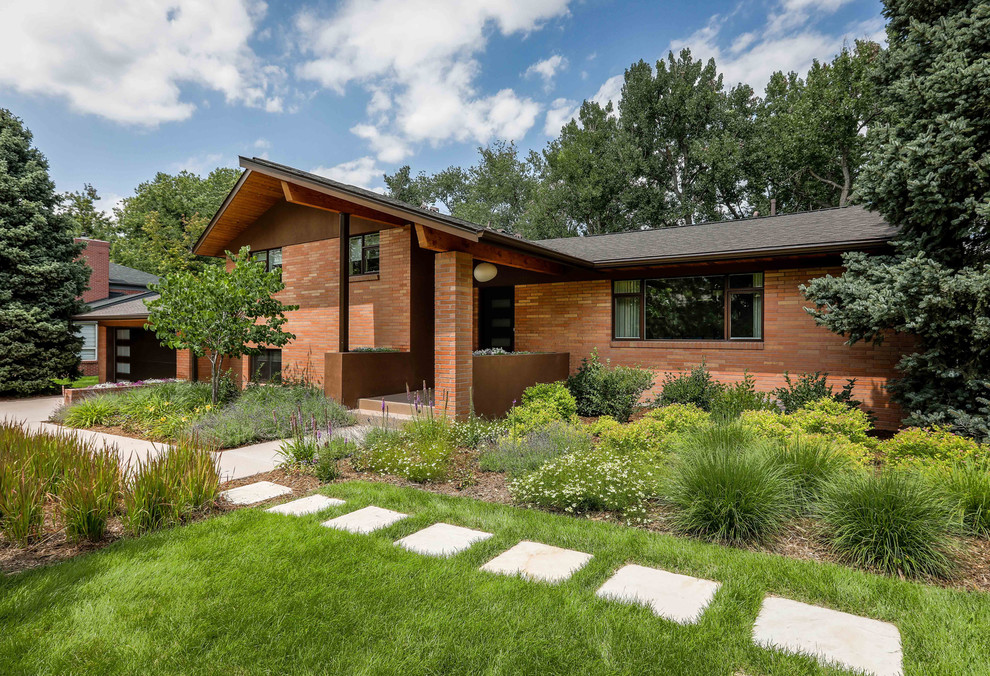 Large and red modern two floor brick detached house in Denver with a shingle roof.