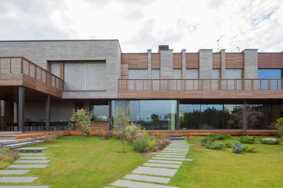 Ejemplo de fachada de casa moderna de dos plantas con revestimientos combinados y tejado plano