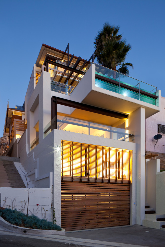 Photo of a contemporary house exterior in Sydney with three floors, mixed cladding and a flat roof.