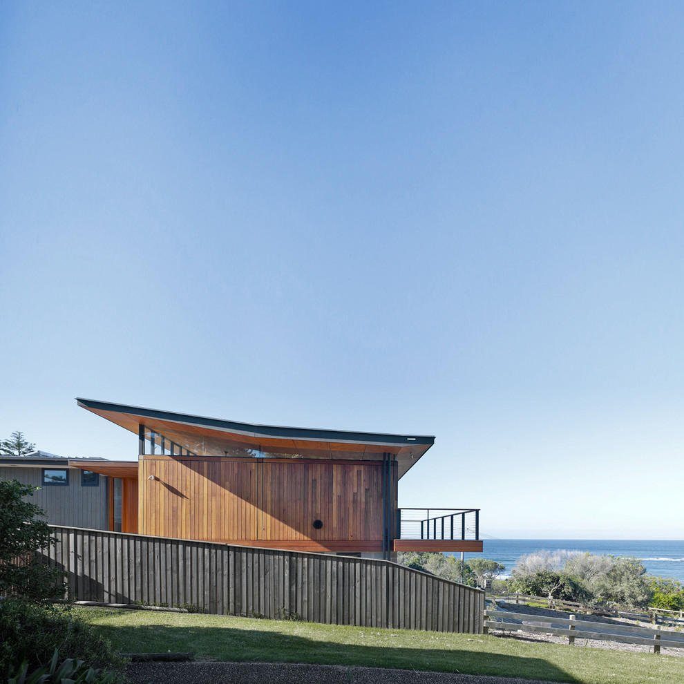 Diseño de fachada de casa marrón contemporánea de tamaño medio a niveles con revestimiento de madera y tejado de metal