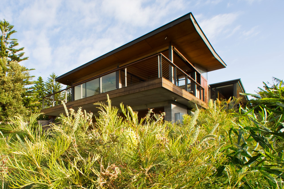Mittelgroßes Modernes Einfamilienhaus mit Glasfassade, brauner Fassadenfarbe und Blechdach in Sydney