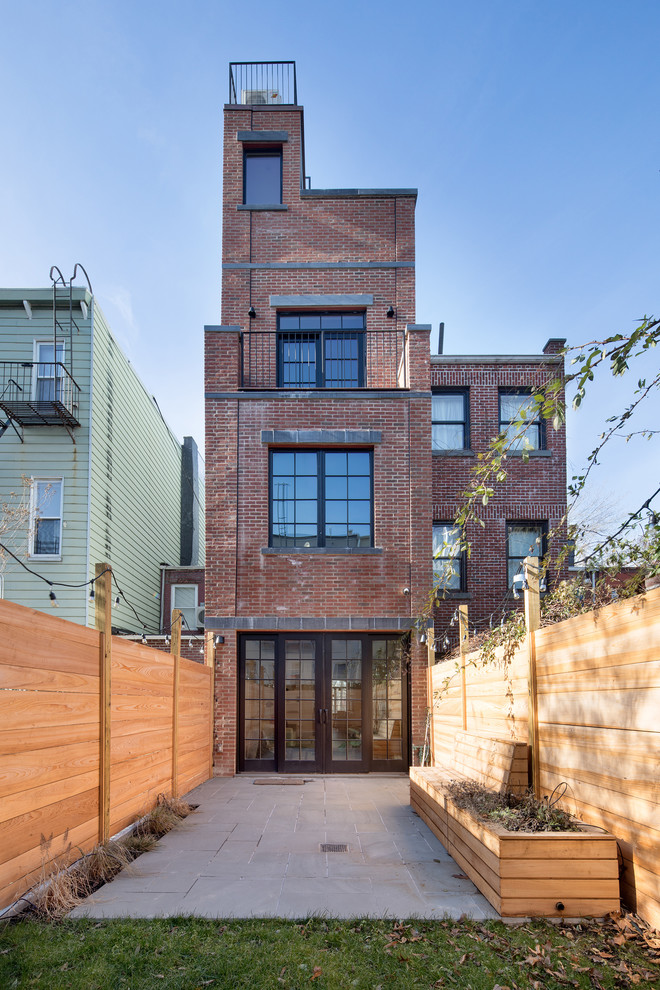 Urban red three-story brick exterior home photo in New York