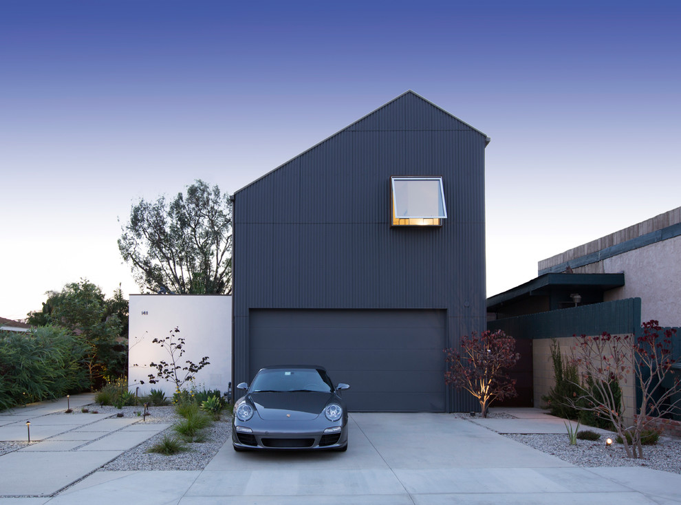 Ejemplo de fachada de casa azul urbana grande de dos plantas con revestimiento de metal y tejado de teja de madera