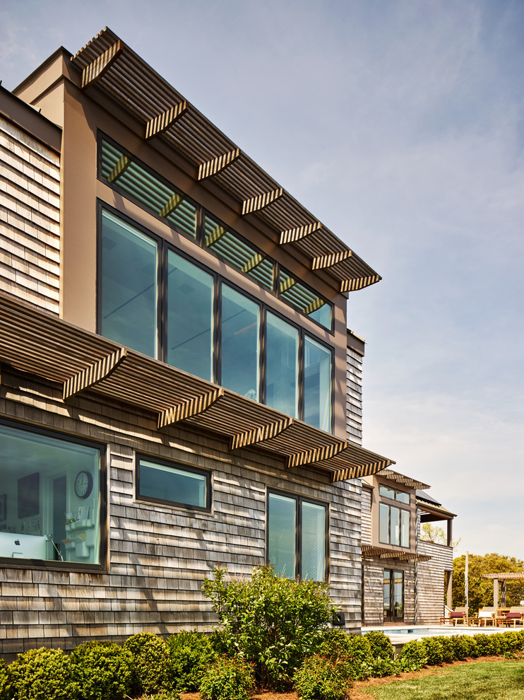 Großes, Zweistöckiges Modernes Haus mit beiger Fassadenfarbe, Satteldach und Schindeldach in New York