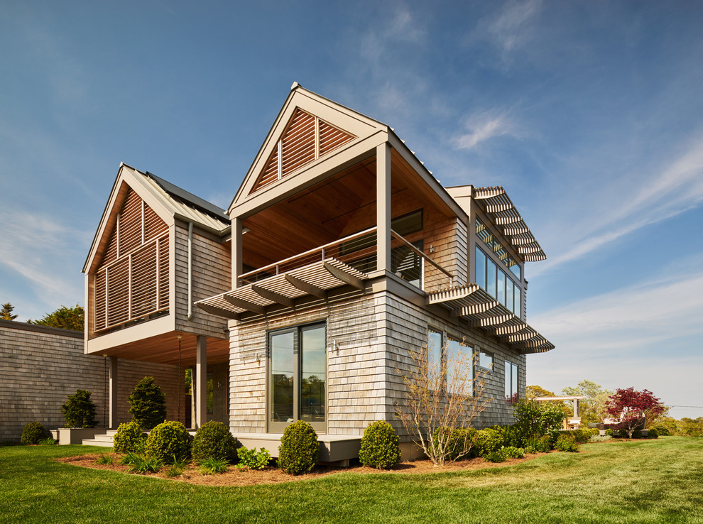 Idee per la villa grande beige moderna a due piani con rivestimento in legno, tetto a capanna e copertura a scandole