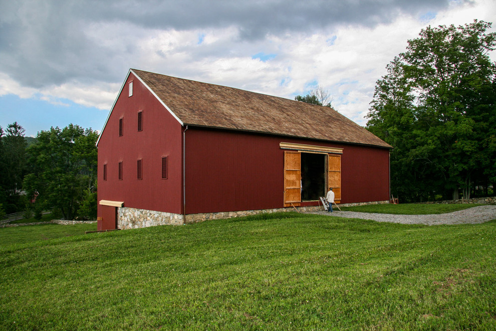 На фото: большой, трехэтажный, деревянный, красный дом в стиле кантри с двускатной крышей с