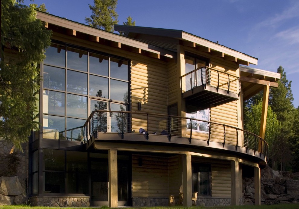 На фото: большой, коричневый частный загородный дом в стиле рустика с облицовкой из бетона и односкатной крышей с