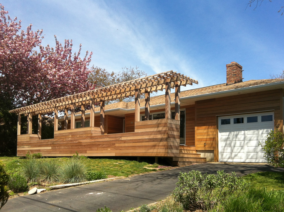 This is an example of a medium sized and brown contemporary bungalow house exterior in New York with wood cladding.