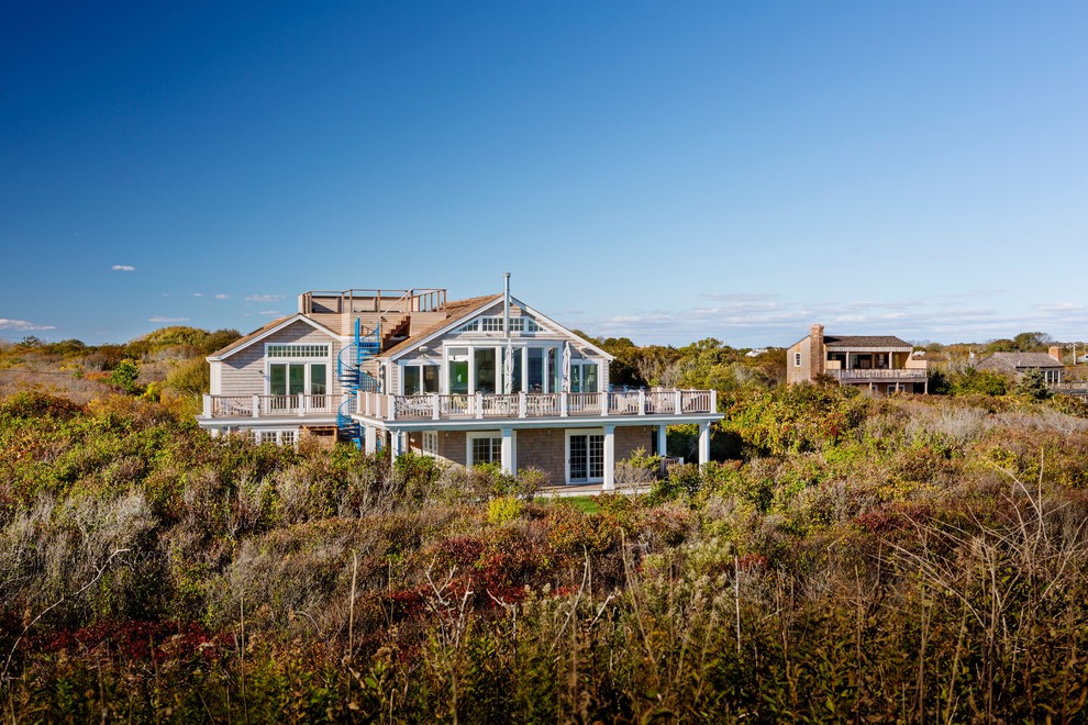 Immagine della villa grande beige stile marinaro a due piani con rivestimento in legno, tetto a padiglione e copertura a scandole