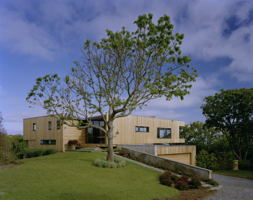 Imagen de fachada de casa marrón moderna grande de dos plantas con revestimiento de madera y tejado plano