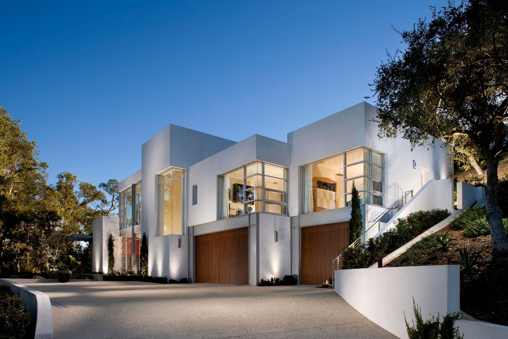 Cette image montre une grande façade de maison blanche minimaliste à un étage avec un toit plat.