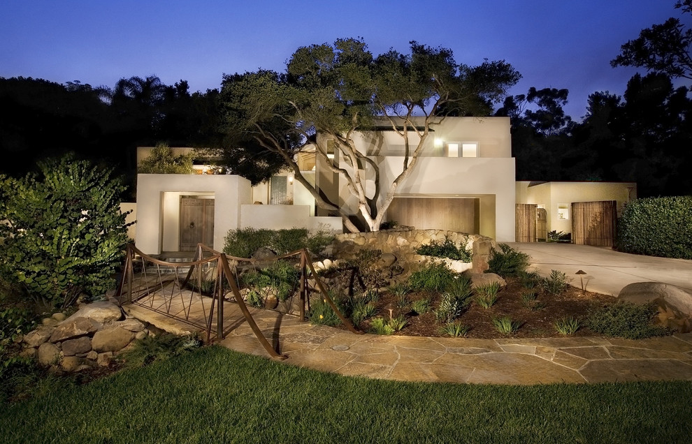 Large trendy beige two-story stucco flat roof photo in Santa Barbara