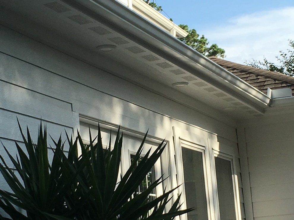 Ejemplo de fachada blanca tradicional de tamaño medio de dos plantas con revestimiento de madera y tejado a dos aguas