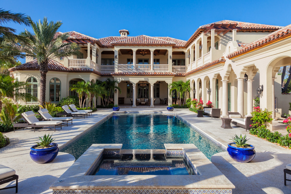 Photo of a beige mediterranean two floor house exterior in Miami.