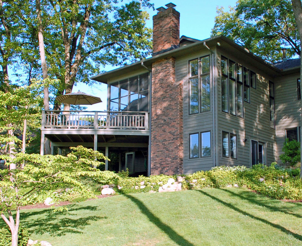 Aménagement d'une façade de maison grise classique en bois à un étage et de taille moyenne avec un toit à quatre pans et un toit en shingle.
