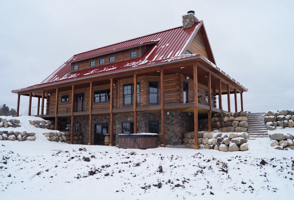 Свежая идея для дизайна: двухэтажный, коричневый дом среднего размера в стиле рустика с двускатной крышей для охотников - отличное фото интерьера