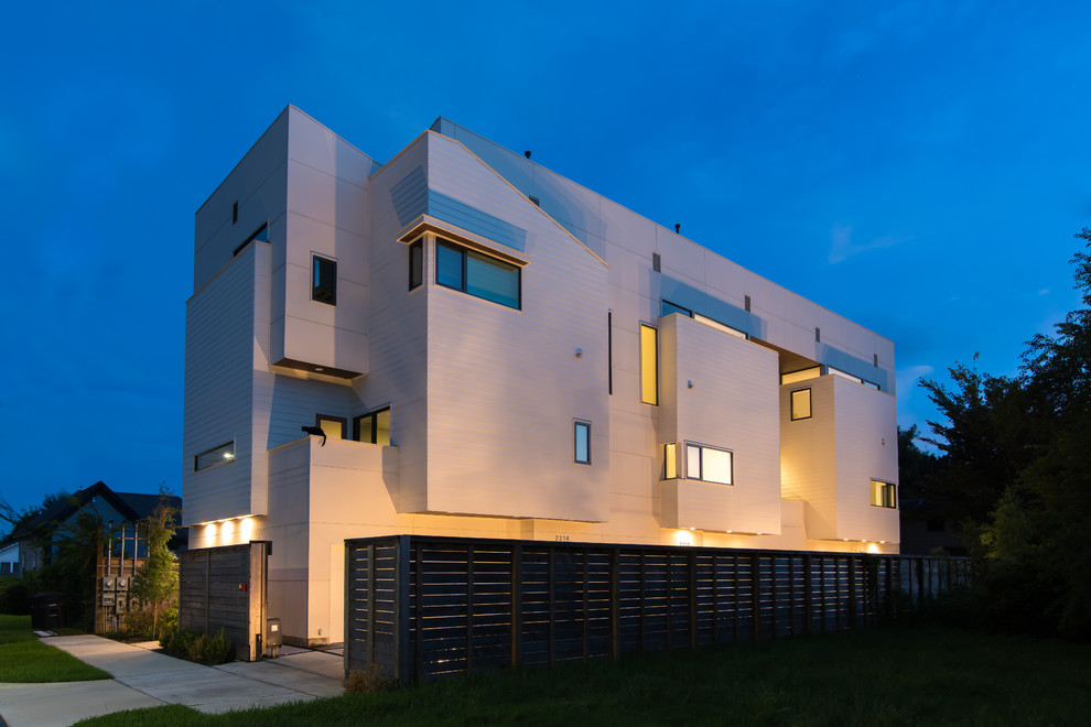 Esempio della facciata di una casa grande bianca moderna a tre piani con rivestimento in vinile e tetto piano