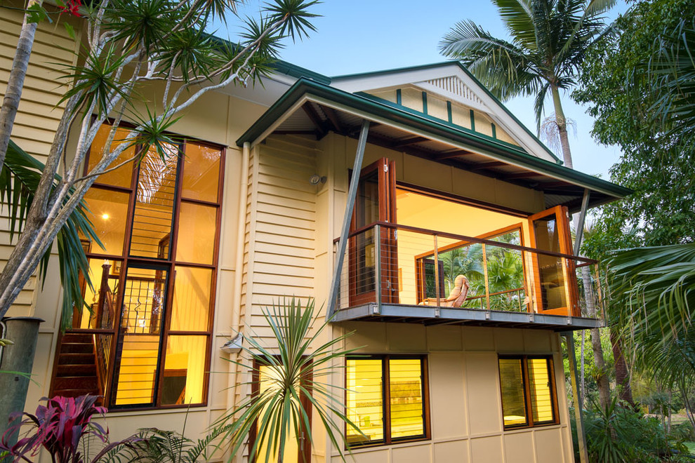 Foto de fachada de casa multicolor tropical grande de dos plantas con tejado a cuatro aguas y tejado de metal