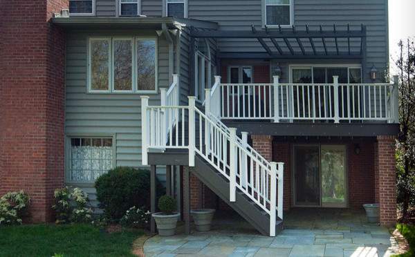 Cette photo montre une façade de maison grise éclectique de taille moyenne et à deux étages et plus avec un revêtement en vinyle et un toit plat.